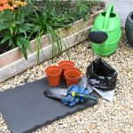 a-garden-with-pots-and-gardening-tools-on-the-ground